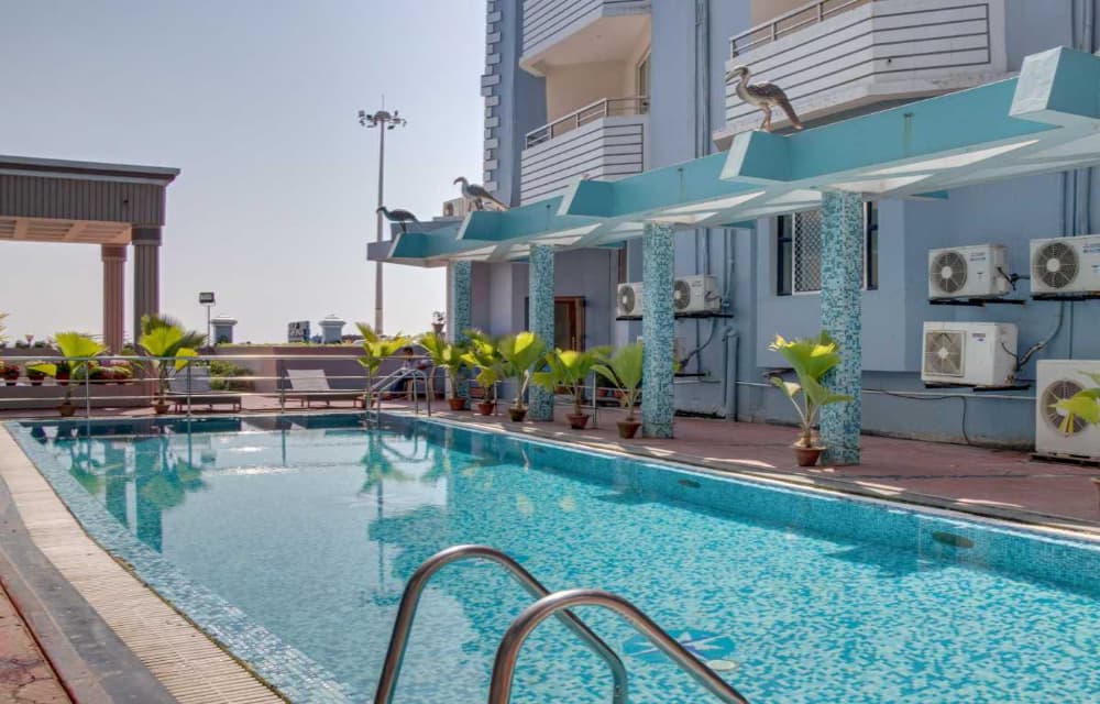 Outdoor swimming pool and sun deck at Hotel Prabhupada Puri
